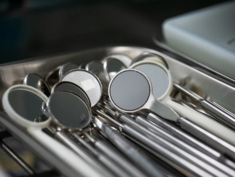Clean dental mirrors and instruments lined up on a steel tray