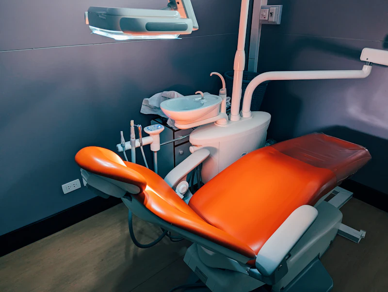 An empty dental chair with its light and instruments ready